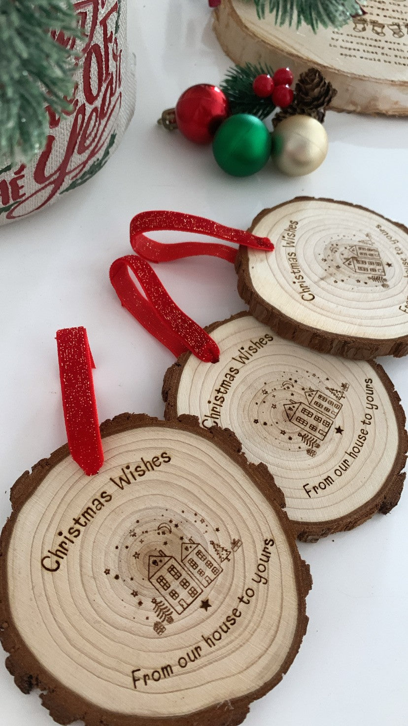 Laser engraved wooden Christmas ornament that reads “Christmas Wishes From Our House to Yours,” displayed with rustic jute twine and festive holiday décor