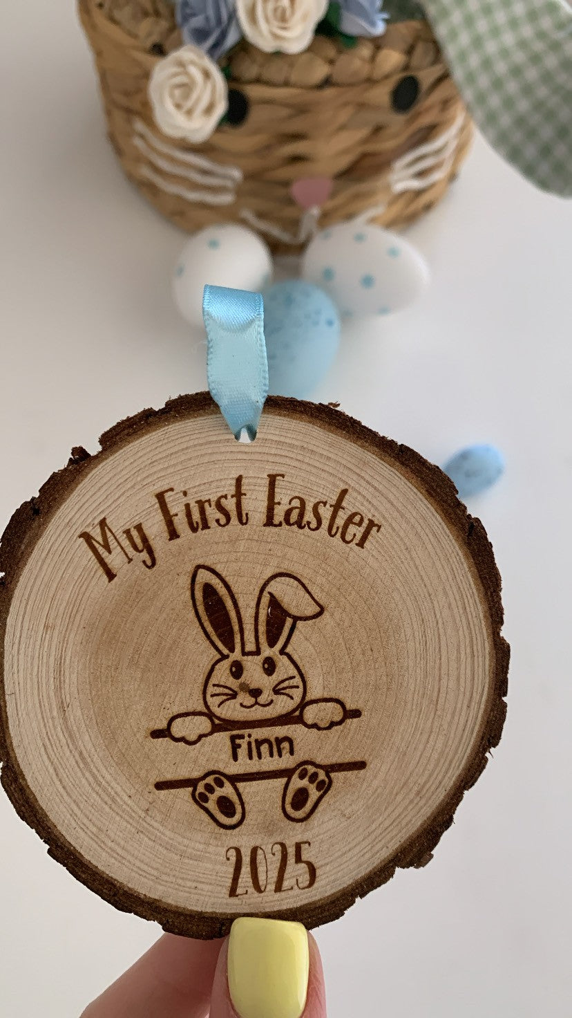 Wooden ornament with engraved bunny and text 'My First Easter Finn 2025' held by a hand.