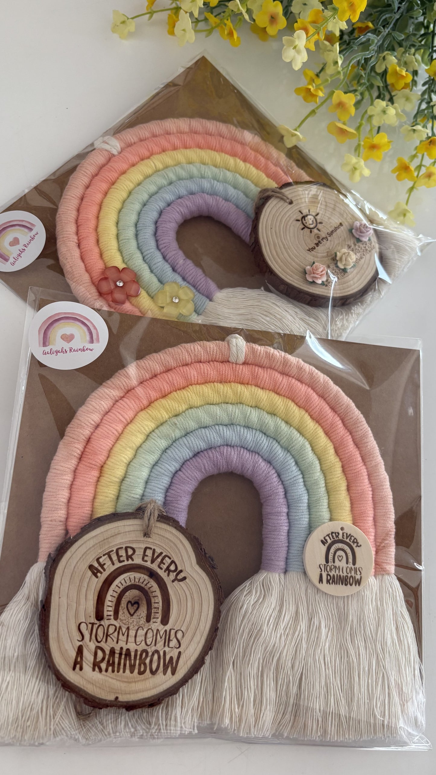 Handmade pastel macrame rainbow wall hanging with engraved wooden tag that reads ‘After every storm comes a rainbow