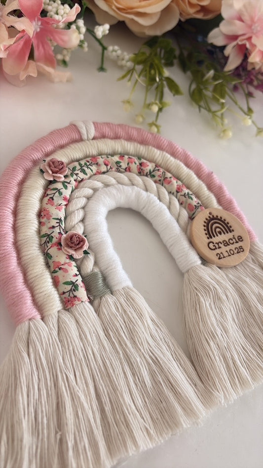 Personalised macramé rainbow baby gift in soft pink, cream and ditsy floral print with wooden engraved tag.