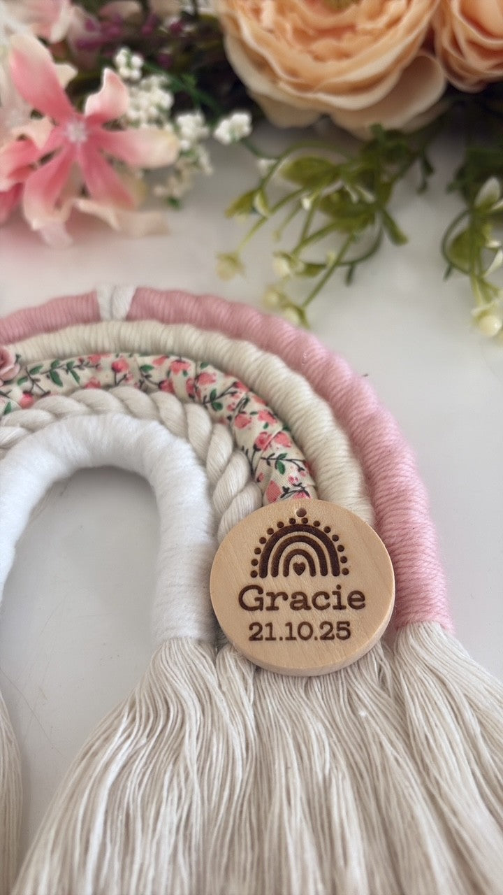 Personalised macramé rainbow baby gift in soft pink, cream and ditsy floral print with wooden engraved tag.