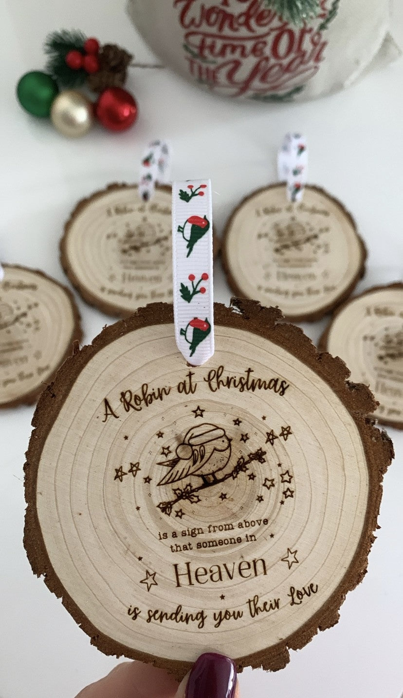 Wooden ornament with engraved message and decorative ribbon on a white background