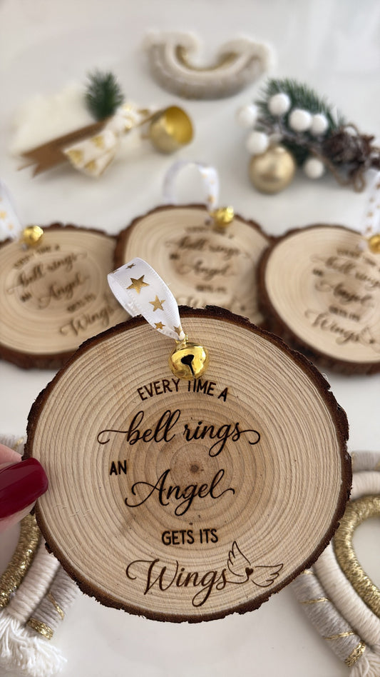 Engraved wooden ornament with “Every time a bell rings, an angel gets its wings” quote and gold ribbon
