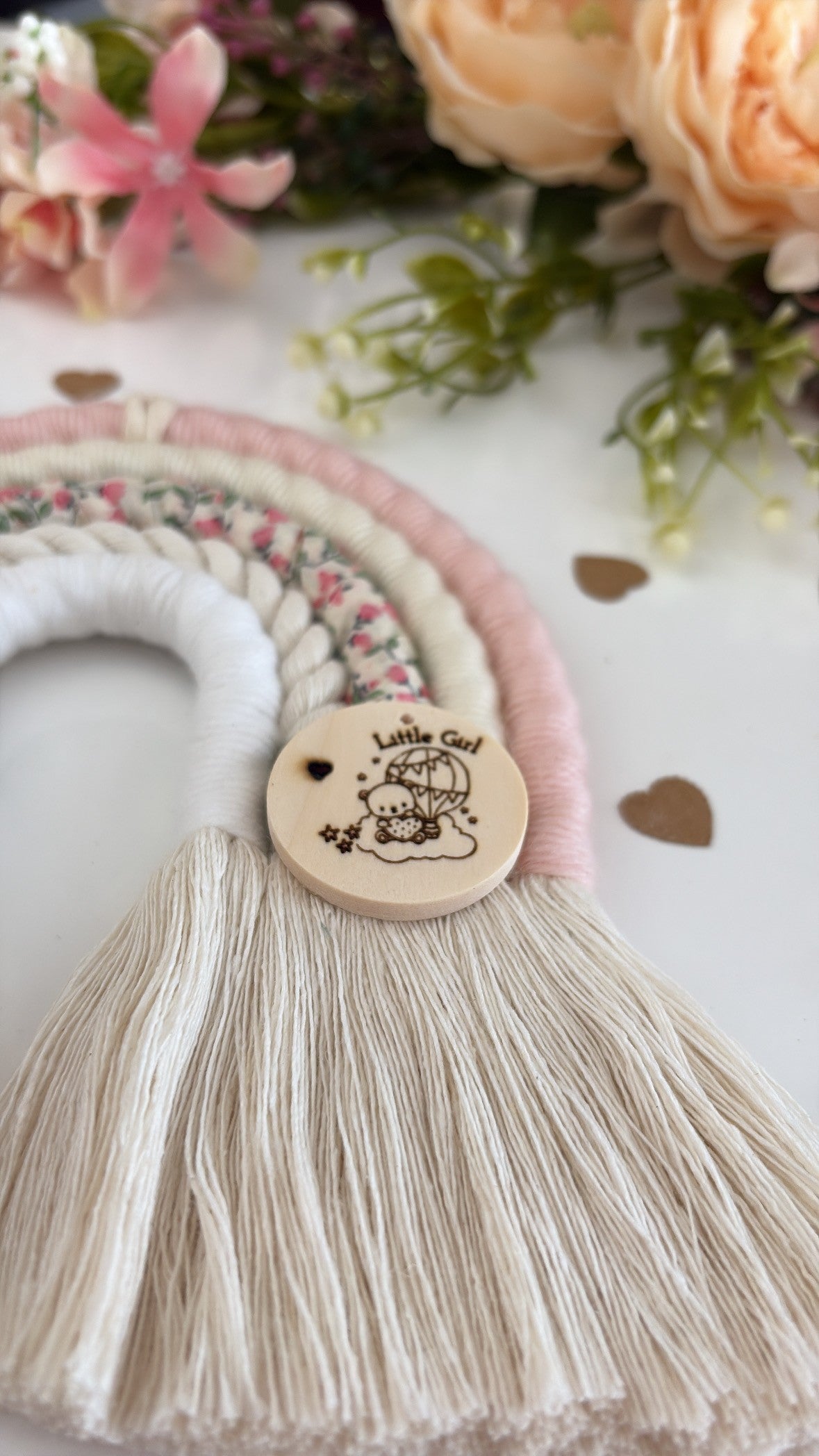 Handmade pink and floral macrame rainbow wall hanging with wooden tag engraved ‘Hello World, Little Girl,’ beautifully wrapped and ready for gifting