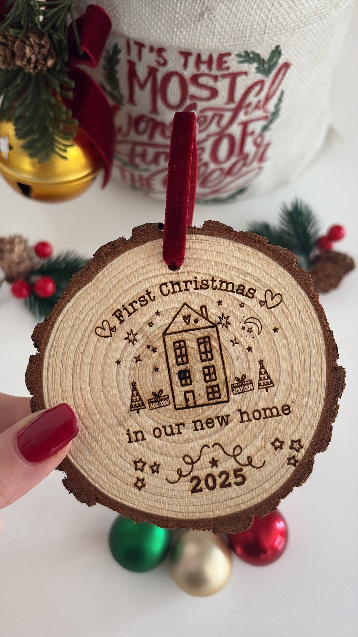 Engraved wooden disc with “First Christmas in Our New Home” message, ideal keepsake for new homeowners.